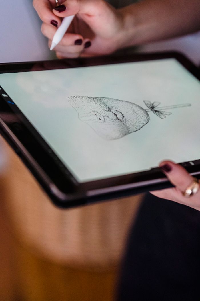 Crafting Captivating Headlines: Your awesome post title goes here Close-up of hands drawing a pear on a tablet, showcasing digital artistry.